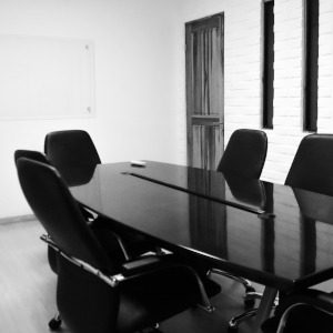 Besprechungsraum - Kolleg:innen Moderner Besprechungsraum mit einem runden schwarzen Tisch und schwarzen Stühlen.